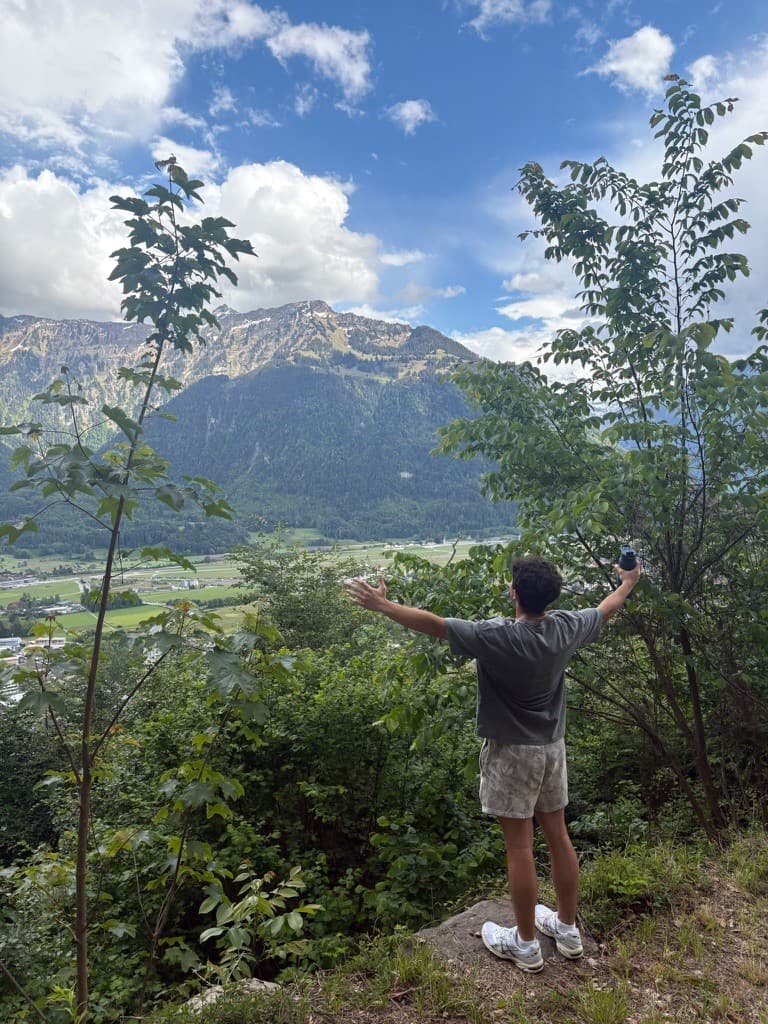 Looking out over a mountain valley with arms outstretched